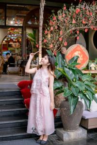 a little girl in a pink dress eating fruit at Seahorse Tropical Da Nang Hotel by Haviland in Da Nang