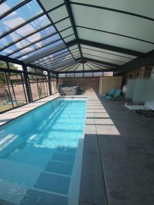 an indoor swimming pool with a glass roof at Chambres d'Hôtes des Rouets in Fourmies