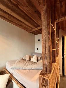 a bed in a room with wooden beams at Le Nid de l'Aiguille - Au pied de l'Aiguille du midi in Chamonix-Mont-Blanc