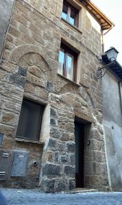a stone building with windows on the side of it at La Chicca di Sofy in Orvieto