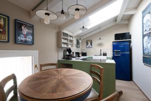 a kitchen with a wooden table and a blue refrigerator at Nido di Borgo35 in Parma