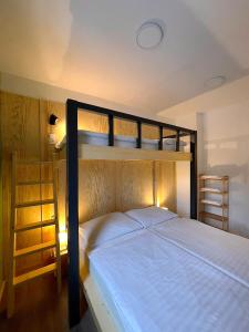a bedroom with two bunk beds with white sheets at Penzion Mája in Josefuv dul