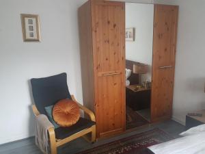 a bedroom with a chair and a wooden cabinet at 4 mereside walk in Manchester
