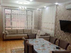 uma sala de estar com um sofá e uma mesa com cadeiras em Green villa em Gabala