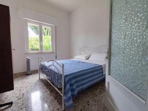 a bedroom with a bed with a blue and white sheets at l'Araucaria casa vacanze in Marsala
