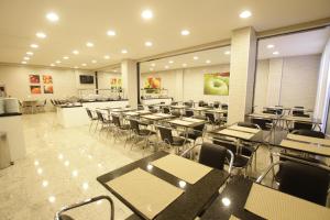 an empty restaurant with tables and chairs in it at Hotel Confiance Centro Cívico in Curitiba