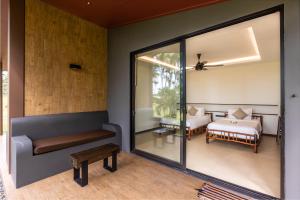 a living room with a couch and a bedroom at Phukhaolak Resort in Khao Lak