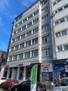 a tall building with cars parked in front of it at Samsun Otel Vidinli in Samsun