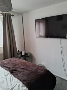 a bedroom with a bed and a flat screen tv on the wall at 4 mereside walk in Manchester