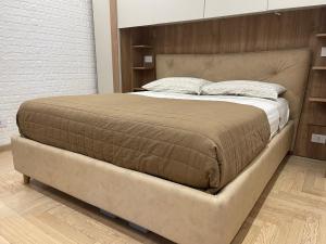un grande letto in una camera da letto con struttura marrone di Suite San Paolo Tv Cinema a Roma