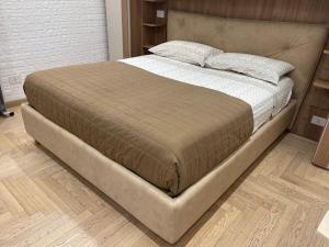 un grande letto in una camera da letto con pavimento in legno di Suite San Paolo Tv Cinema a Roma
