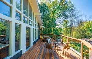 a porch with a table and chairs on a house at Waterfront Haliburton, All Season, Fully Equipped Cottage! in Haliburton