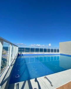 a swimming pool with a view of the ocean at Flat Lindíssimo Beira-Mar in Salvador