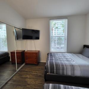 a bedroom with a bed and a flat screen tv at Amazing Lil Italy 2bdr Home Dtla in Los Angeles