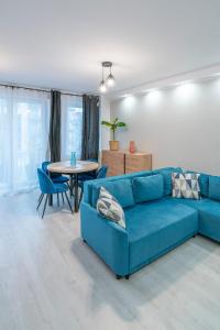 een woonkamer met een blauwe bank en een tafel bij Stylowy apartament Blue ~self check in 24h in Wrocław