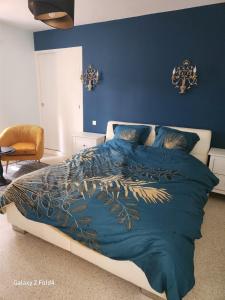 1 dormitorio con 1 cama con pared azul en Le Mazet, en Saint-Ambroix