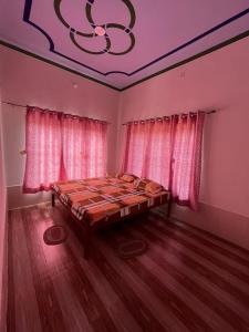Khātuにあるगणेश फेमिली गेस्ट हाउसのピンクのカーテンが備わるベッドルーム1室です。