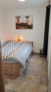 a bedroom with a bed and a tiled floor at Maison d'hôte au bord de la Rivière avec jacuzzi in Épinal