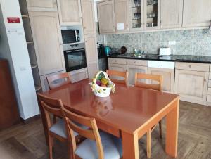 una cocina con una mesa de madera y un bol de fruta. en Casa Sarguito, en Sagres