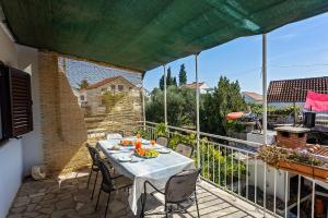 a patio with a table and chairs on a balcony at Apartment Zlatko in Rogoznica