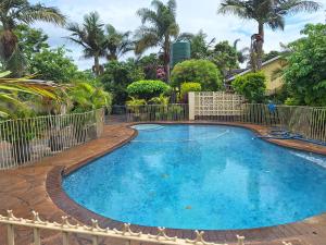 a large swimming pool with a fence around it at Charming 6-Bed House with Swimming Pool in Harare in Harare