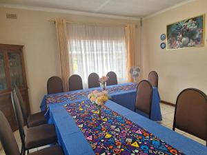 uma sala de conferências com uma mesa com uma toalha de mesa azul em Charming 6-Bed House with Swimming Pool in Harare em Harare