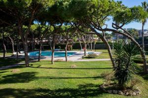 a park with trees and a swimming pool at Wonderful apartment in Gavà. Barcelona in Gavà