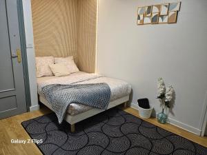 a small bedroom with a bed and a rug at VILLA Zara in Beauvais