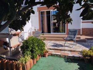 eine Terrasse mit zwei Stühlen und Pflanzen vor einem Haus in der Unterkunft Casa Sarguito in Sagres