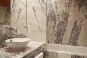 a bathroom with a sink and a bath tub at Grande Hotel do Porto in Porto