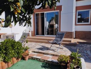 un patio con 2 sillas y una mesa frente a una casa en Casa Sarguito en Sagres