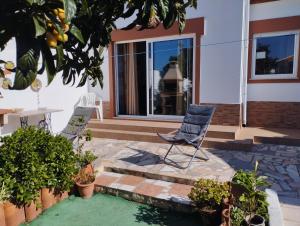 a patio with two chairs and a table in front of a house at Casa Sarguito in Sagres