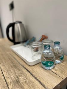 dos botellas de agua sentadas sobre una mesa en الفاتن لشقق الخاصه en Riad