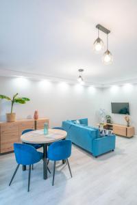 een woonkamer met een tafel en blauwe stoelen bij Stylowy apartament Blue ~self check in 24h in Wrocław