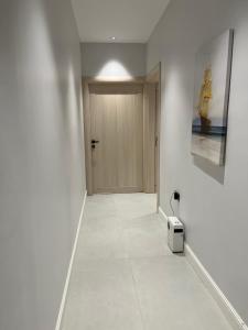 a hallway with a door and a white wall at الفاتن لشقق الخاصه in Riyadh