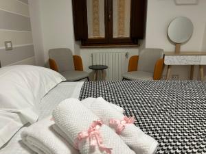 ein Schlafzimmer mit einem Bett mit weißen Handtüchern und Stühlen in der Unterkunft La Chicca di Sofy in Orvieto