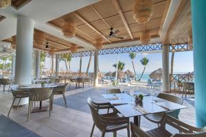 um restaurante com mesas e cadeiras e vista para o oceano em Bahia Principe Grand Turquesa - All Inclusive em Punta Cana