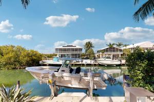 a boat is docked in a marina with houses at Luxurious Haven in Tavernier