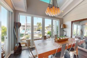 a dining room with a table and chairs and windows at Luxurious Haven in Tavernier