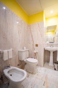 La salle de bains est pourvue de toilettes blanches et d'un lavabo. dans l'établissement Grande Hotel do Porto, à Porto