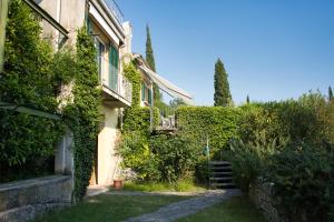an ivy covered building with a stairway in a yard at Villa in the green, extraordinary silent position, great lake view in Garda