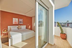 Stayhere Rabat - Hassan - Authentic Residence في الرباط: غرفة نوم بسرير ونافذة كبيرة