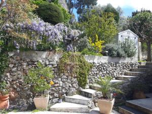 a stone retaining wall with stairs and flowers at Haut de villa Toulon Mourillon in Toulon