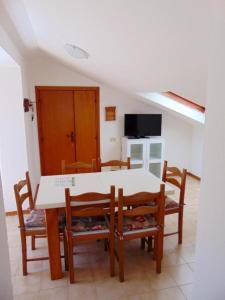 uma sala de jantar com uma mesa branca e cadeiras em Comoda mansarda fronte mare, Marcelli - M249 em Marcelli