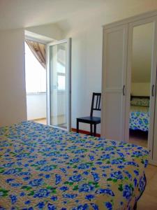 um quarto com uma cama e uma cadeira num quarto em Comoda mansarda fronte mare, Marcelli - M249 em Marcelli