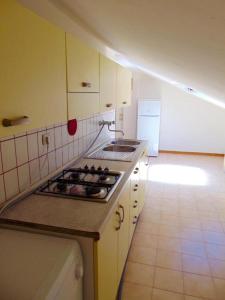 uma cozinha com uma placa de fogão num quarto em Comoda mansarda fronte mare, Marcelli - M249 em Marcelli