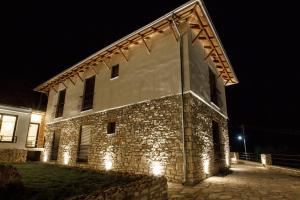 - un bâtiment en pierre avec des lumières allumées la nuit dans l'établissement Bujtina KOEL, à Gjirokastër