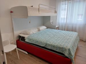 ein Schlafzimmer mit einem Etagenbett mit einem roten Bettrahmen in der Unterkunft Gulliver in Garda
