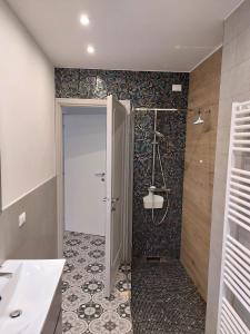 ein Bad mit einer Dusche und einer Glastür in der Unterkunft Gulliver in Garda