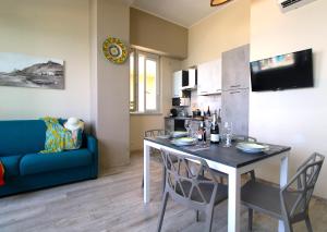un soggiorno con tavolo e divano blu di Capo d'Orlando Apartments - Doria 52 a Capo dʼOrlando